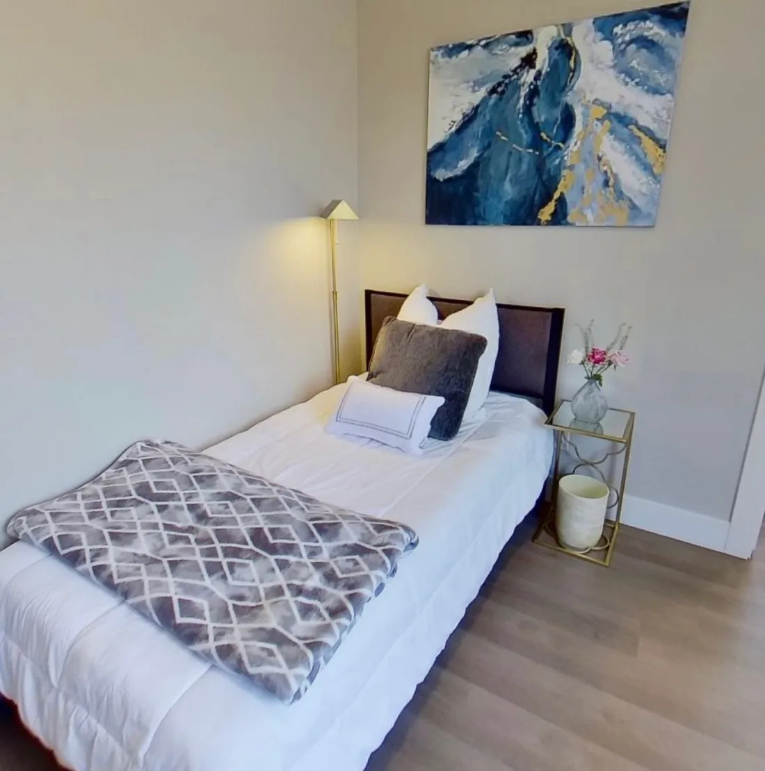 A cozy bedroom with warm bedding and calming art
