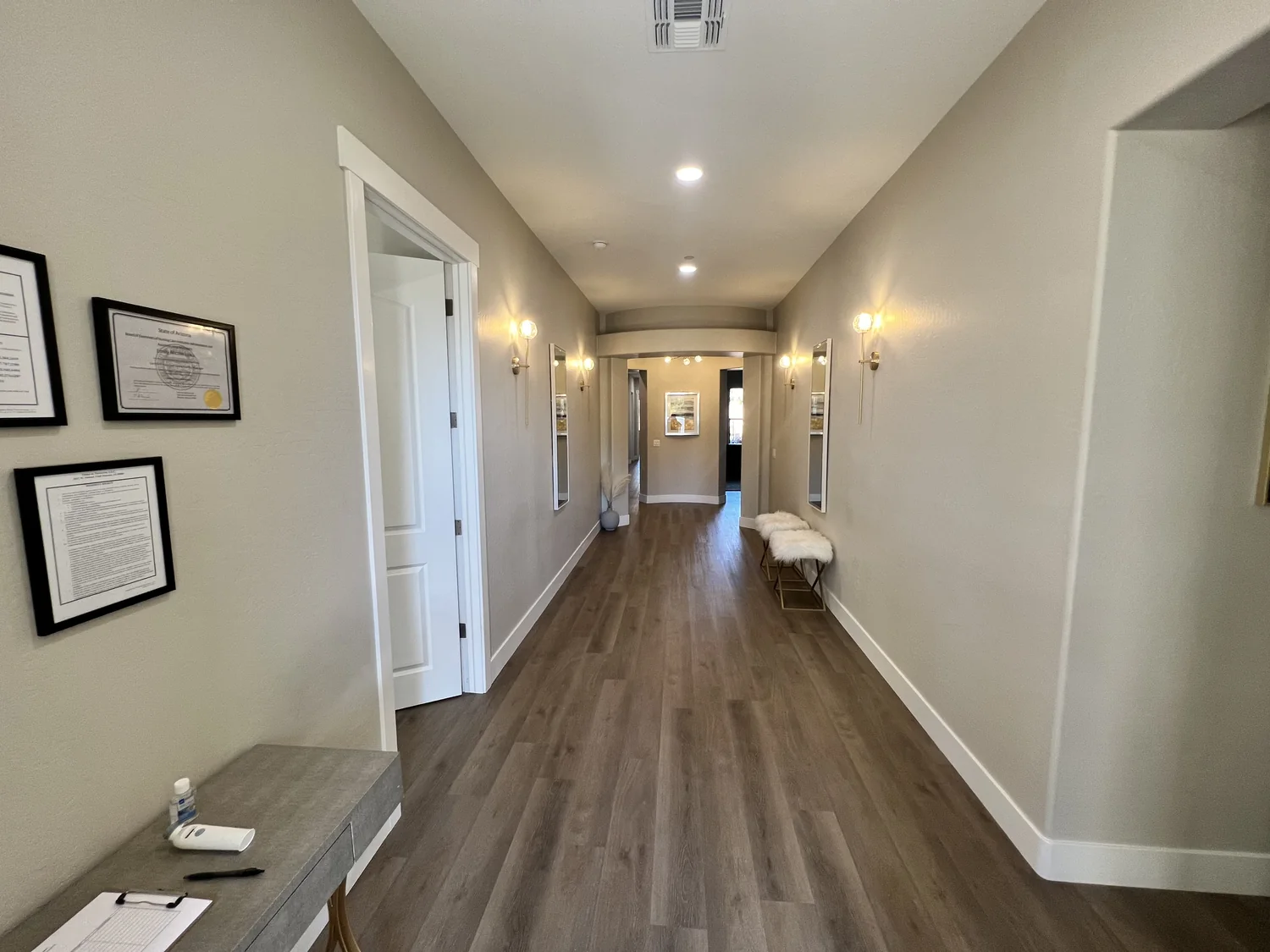 Bright hallway inside the Oasis at Norterra home with warm wood floors and soft lighting